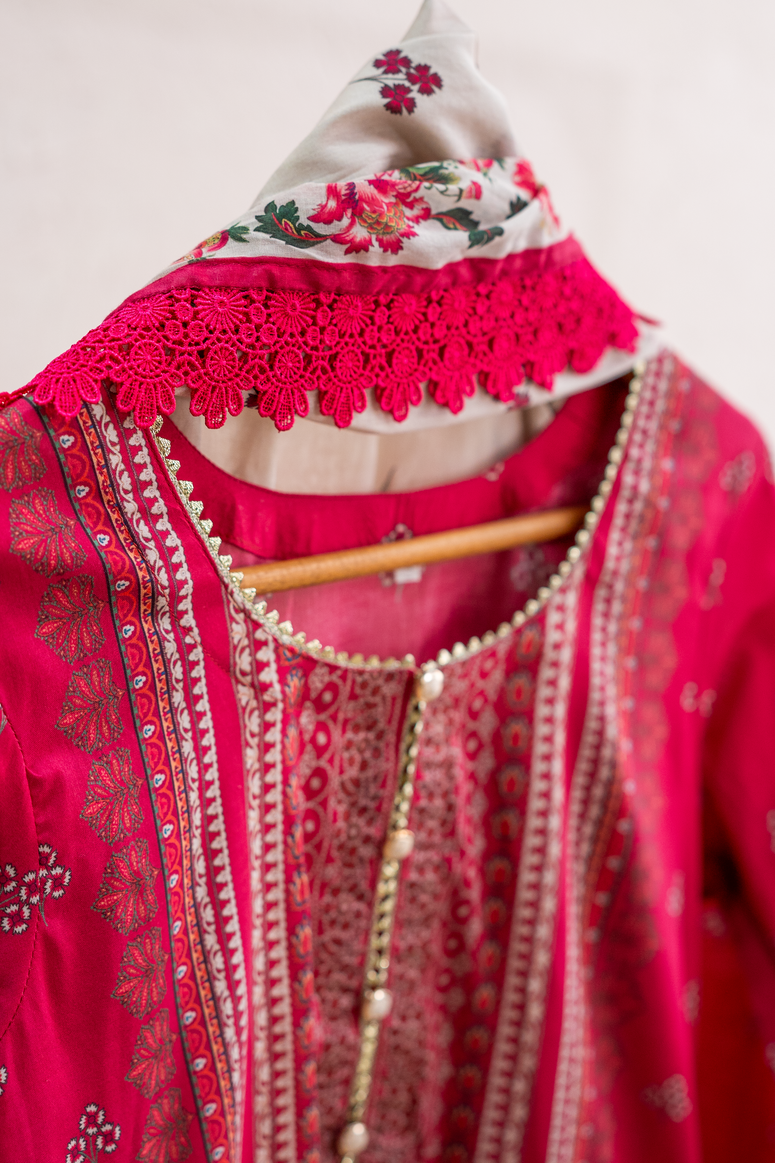 Embellished lace neckline detail of bold pink festive outfit